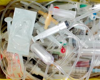 A photo showing a pile of medical waste, including IV tubing and syringes.