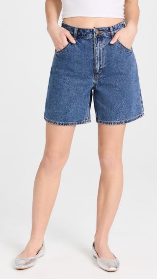 a model wearing mid-length denim shorts