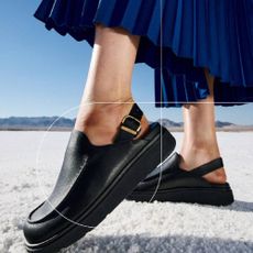 A close-up of a pair of leather mules with a sling back strap from FitFlop. 