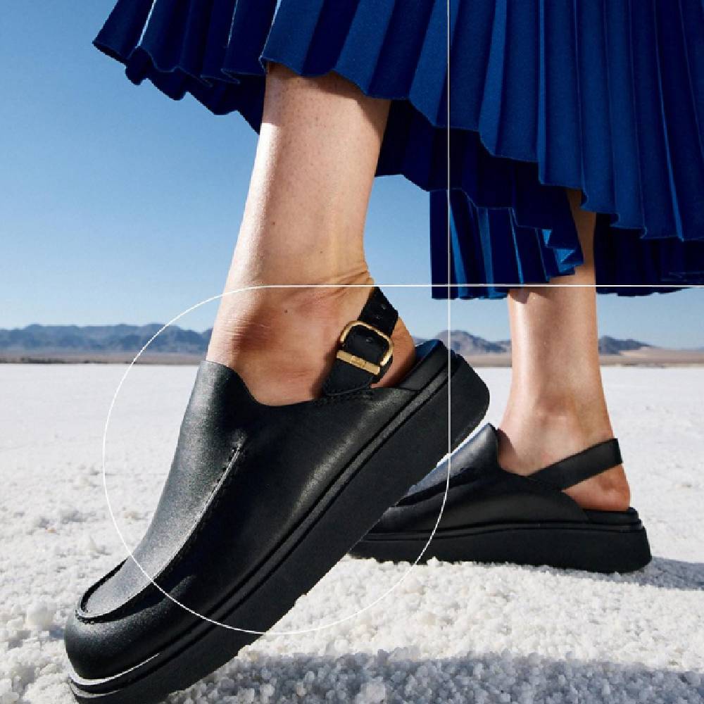 A close-up of a pair of leather mules with a sling back strap from FitFlop. 