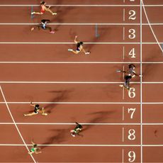 Female athletes crossing the finish line at a track and field event