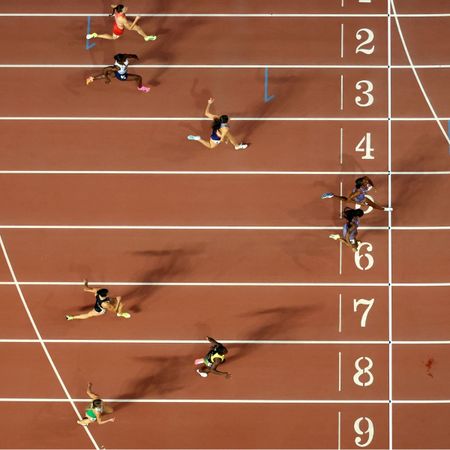 Female athletes crossing the finish line at a track and field event