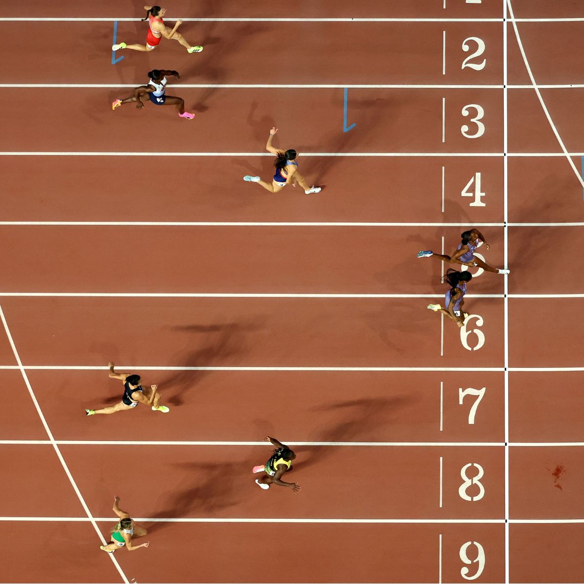 Female athletes crossing the finish line at a track and field event