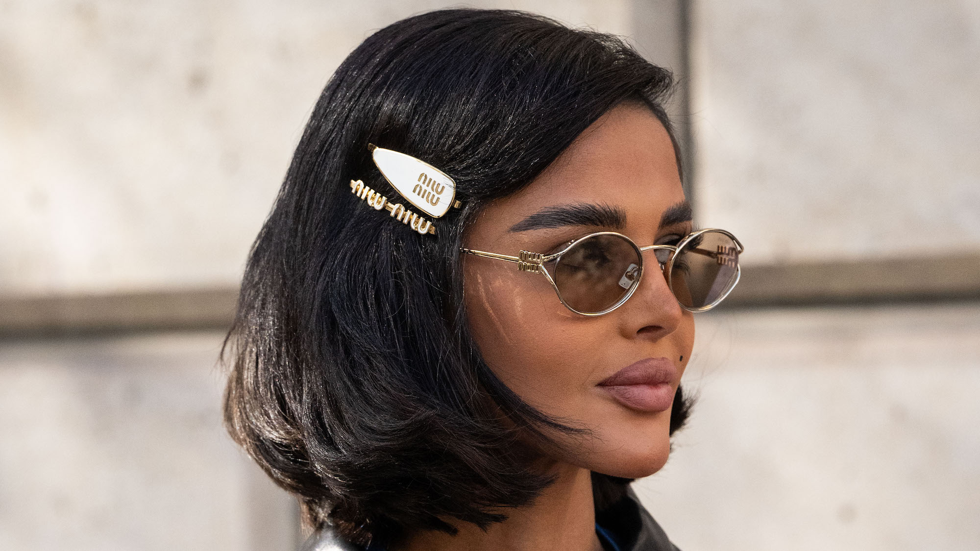 Mariam Mohammad wears a Miu Miu jacket, dress, sunglasses and hair clips