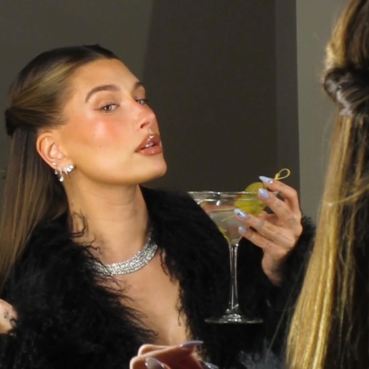 Hailey Bieber holding a martini
