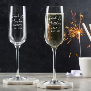 champagne glasses with sparkler on white table
