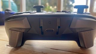 A black GameSir T4 Cyclone Pro controller sitting on a wooden desk