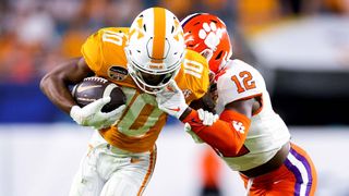 Sherrod Covil Jr. #12 of the Clemson Tigers tackles Squirrel White #10 of the Tennessee Volunteers during the second half in the Capital One Orange Bowl at Hard Rock Stadium on December 30, 2022 in Miami Gardens, Florida.
