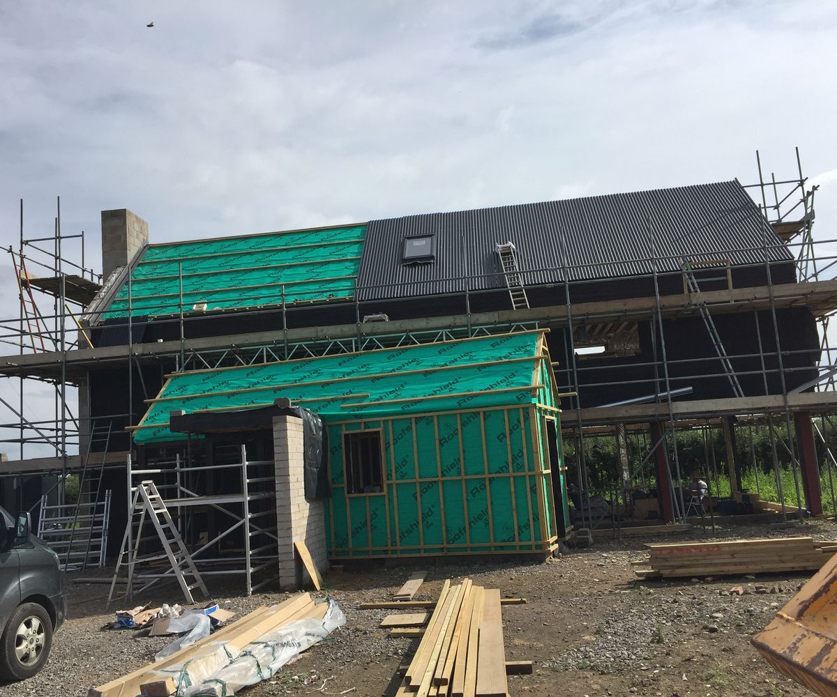 An in-progress picture of a self build home with scaffolding