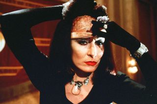 anjelica huston as a witch removing her mask in the witches