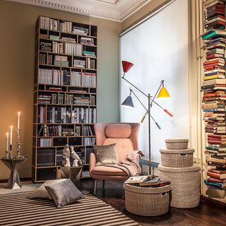 living room with large book she;bves striped rug and comfy pink armchair by delight FULL