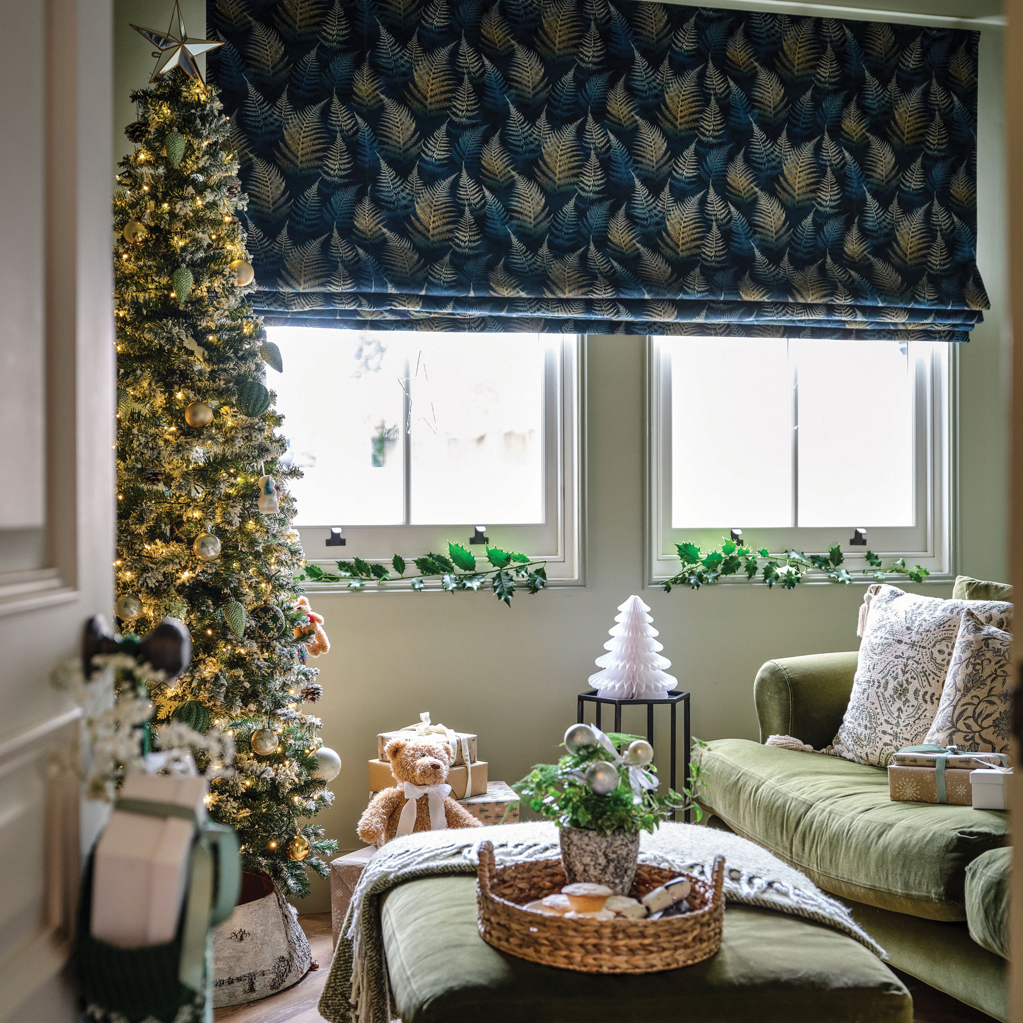 Sage green snug with green velvet sofa with blue blinds