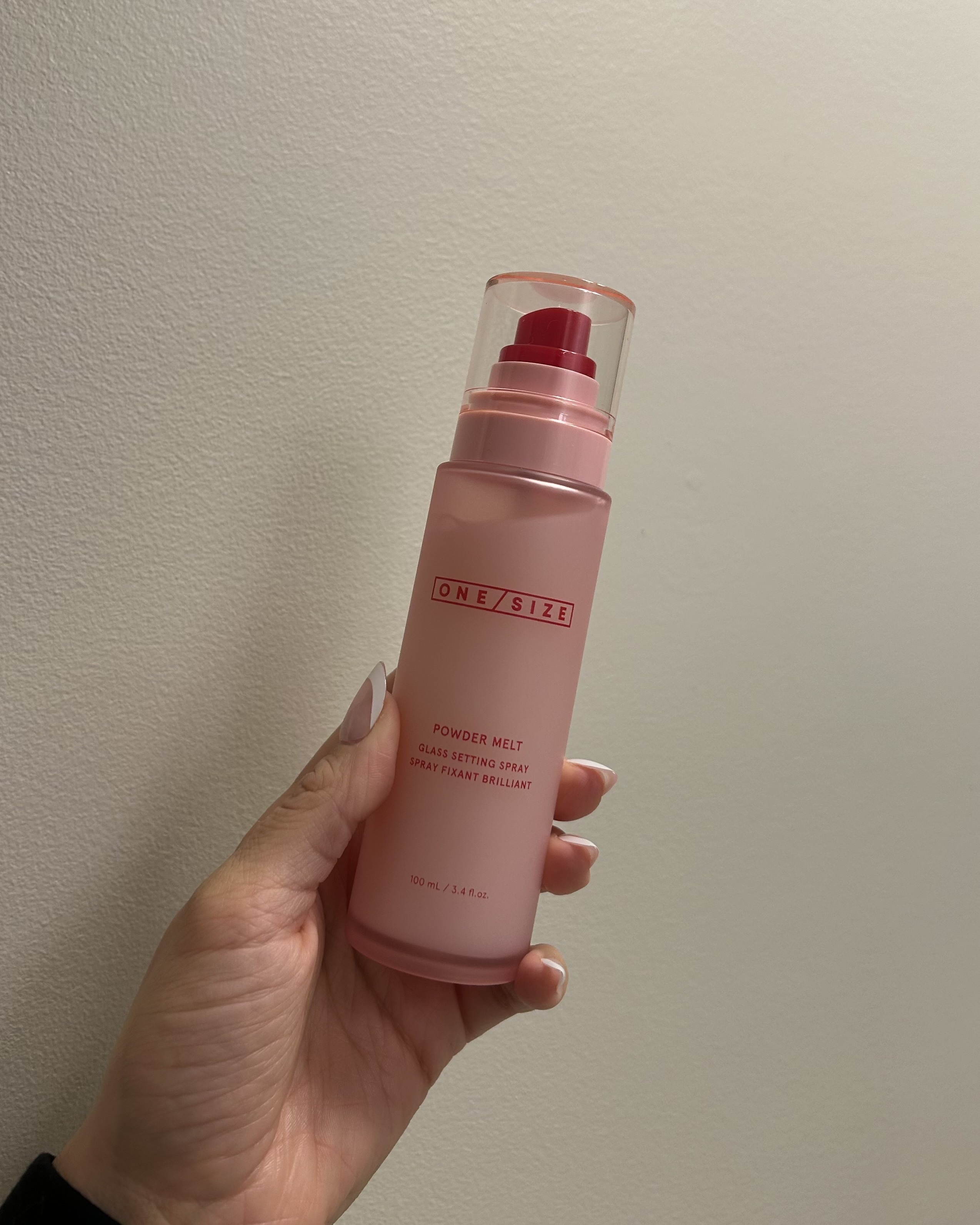 Alyssa Brascia holding the One/Size Powder Melt Glass Setting Spray.