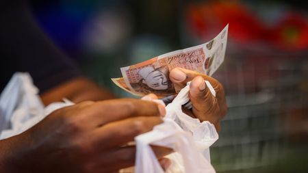 a ten pound note in someone's hand