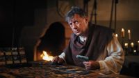 A man in peasant clothing plays the Kingdom Come: Deliverance board game.