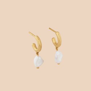 Flat lay image of gold and pearl earrings