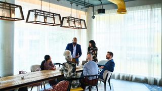 Boardroom meeting with executives, including CEO, CISO, CTO, CIO and CFO discussing company strategy.