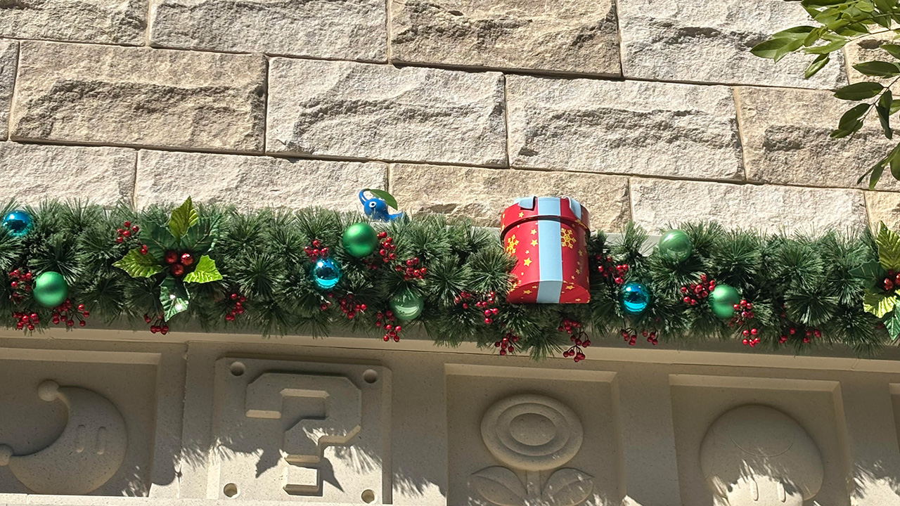 The Pikmin hiding out at the Nintendo Super Store at Epic Universe. The building is decorated for Christmas in the pic.