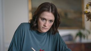 Charlotte Ritchie in a green top as Alison looks pensive in Ghosts.