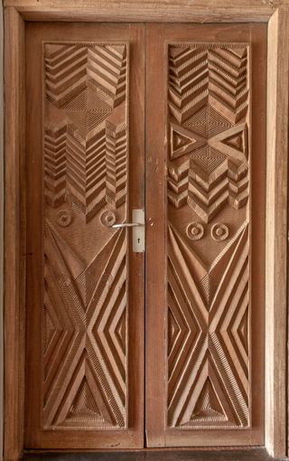 Decoratively carved wooden doors, metal door handle