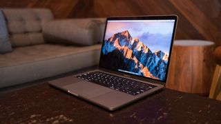 a MacBook Pro on a coffee table next to a couch