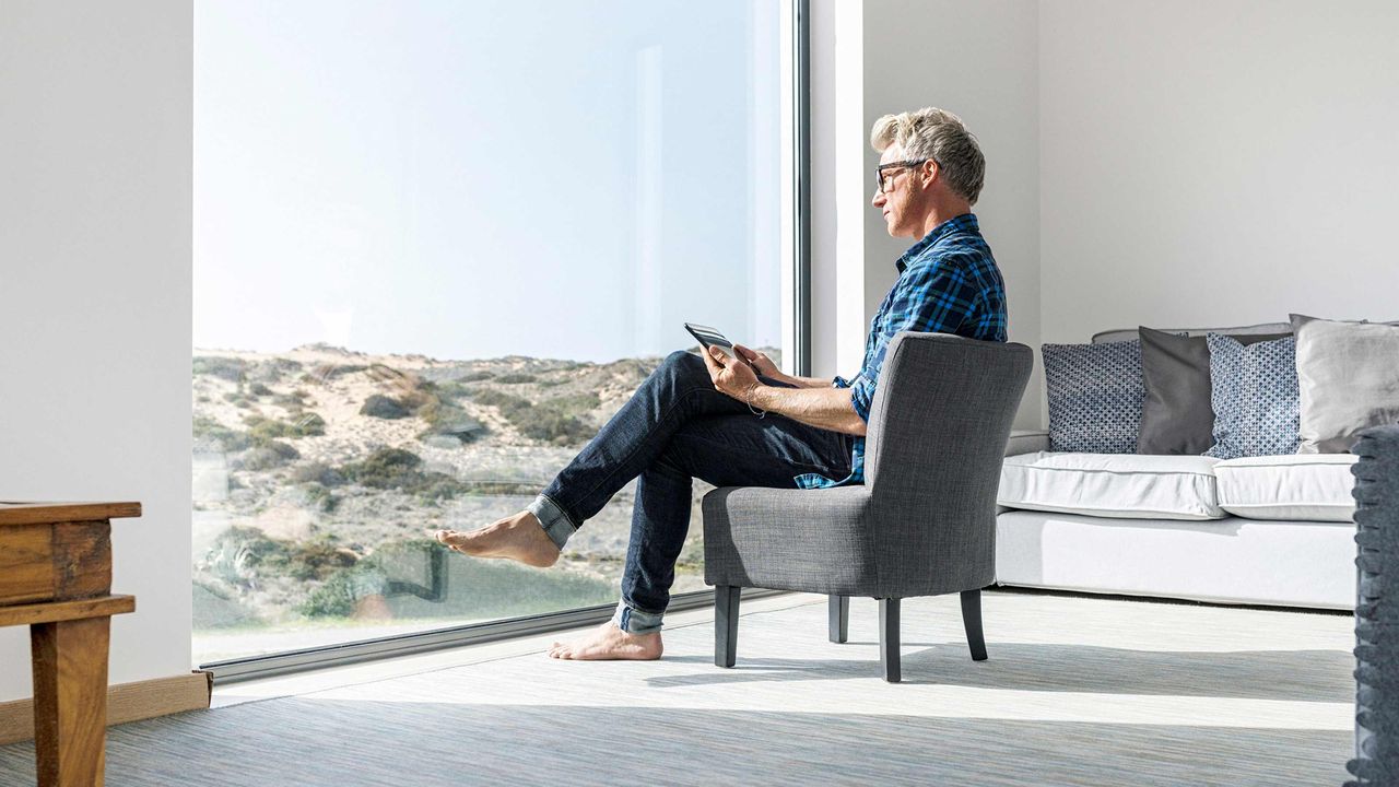 A man reads in an opulent, stark white home.