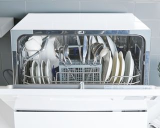 white dishwasher with cutlery and spoon rack