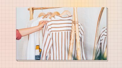 woman taking white and brown striped shirt off wooden clothes rack in neutral room