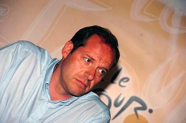 Looking grim, Christian Prudhomme, Tour de France director thinks before answering a reporter's question.