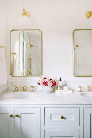 white bathroom vanity with elegant wall lights above the vanity