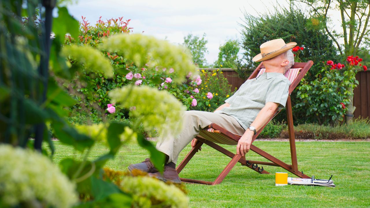 Gardener sleeping in a lawn chair because he has low-maintenance front yard landscaping