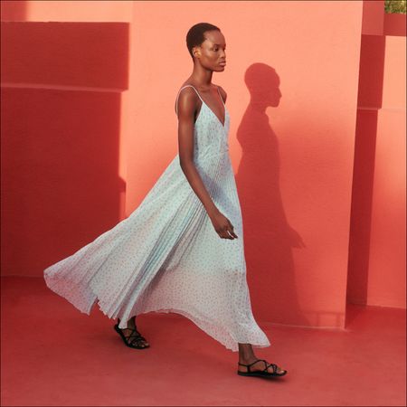 A woman wearing a blue dress from Clare Waight Keller's Spring 2024 Uniqlo:C collection