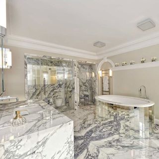 bathroom with italian book matched marble and freestanding bathtub