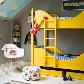 bedroom with white chair and yellow cabin bed