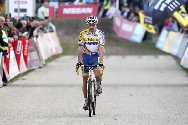 Bart Wellens stretches tired muscles as he crosses the line.