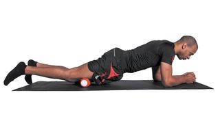 Man uses foam roller on his glutes
