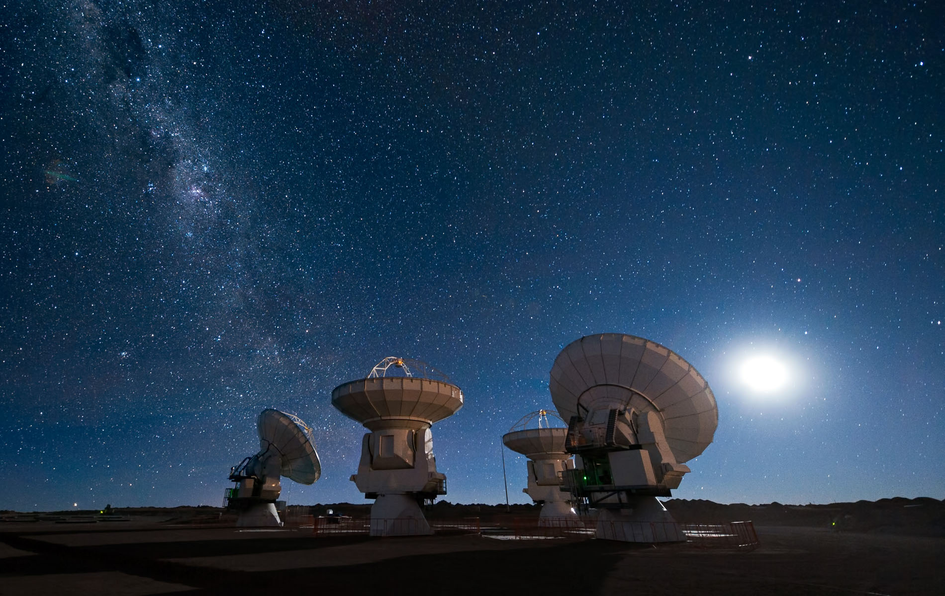 Four of the European Southern Observatory's Atacama Large Millimeter/submillimeter Array (ALMA) antennas gaze up at the night sky. Milky Way is visible at left.