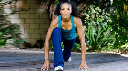 Woman in blue workout kit doing flexibility stretches