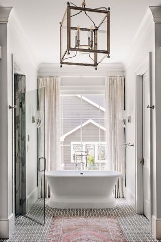 bathroom with full height window and freestanding bath oriental style rug