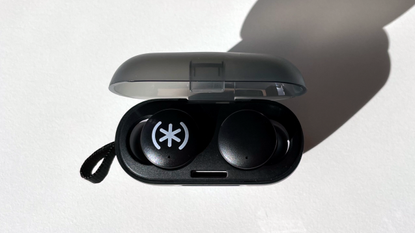 A view from directly above the Speck Gemtones Play earbuds are shown sitting in their charging case sitting on a white table top