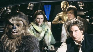 the main cast of return of the jedi are all sat together in a spacecraft. There is a large wookiee on the left then a woman with her hair braided on top of her head then behind is a golden robot shaped like a person, in front of the robot is a man with a concerned look on his face and in front of his is another man with an equally concerned look on his face.