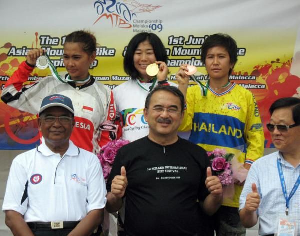 The elite women's downhill top three with event VIPs.