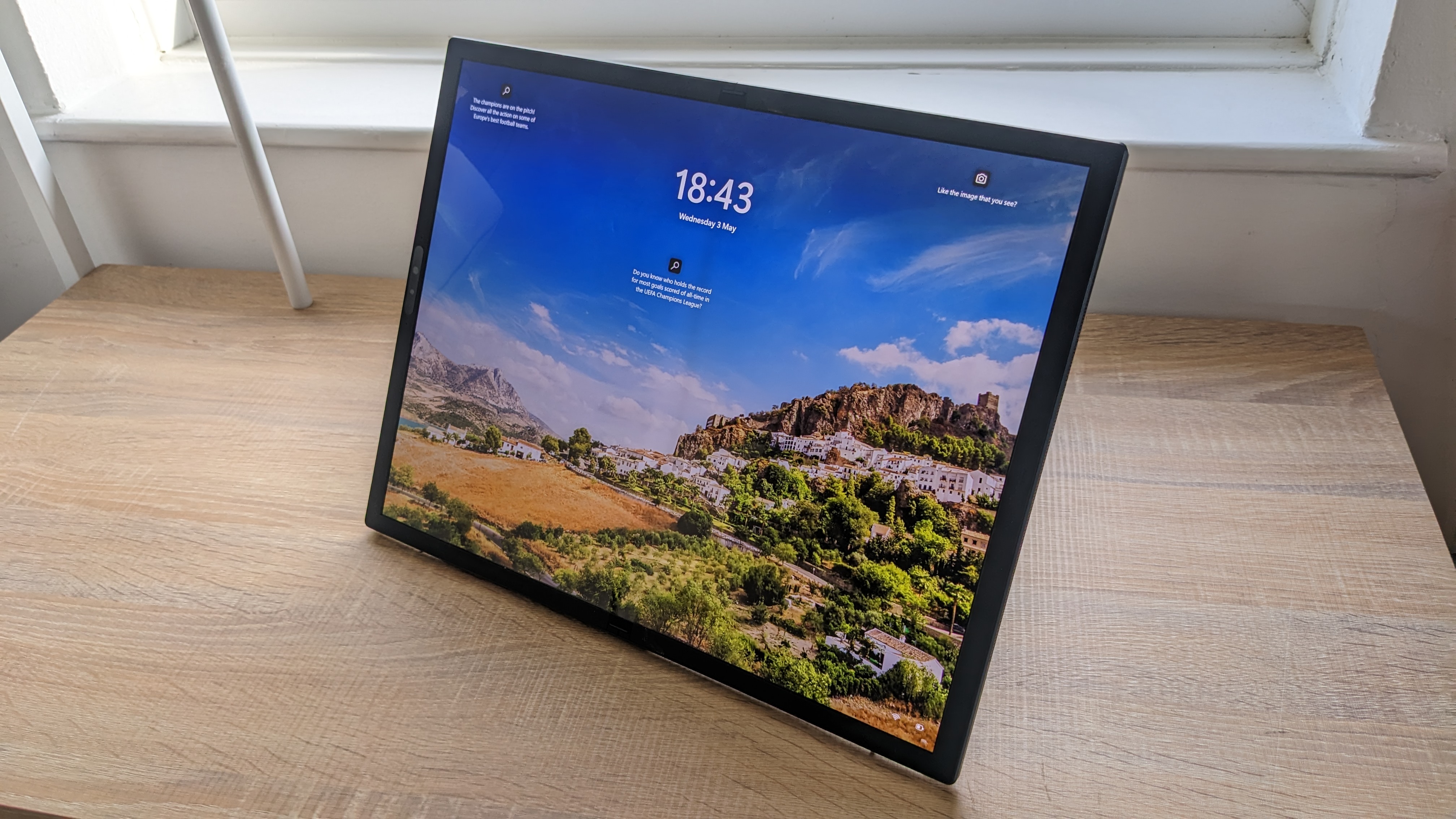 The Asus Zenbook 17 Fold OLED pictured on a wooden desk.