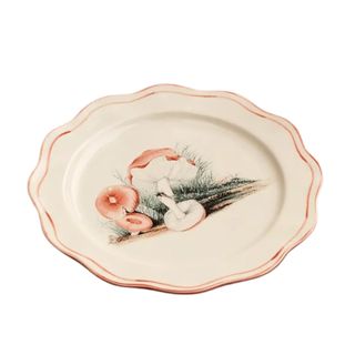 A ceramic plate with wavy edges and a pink mushroom illustration