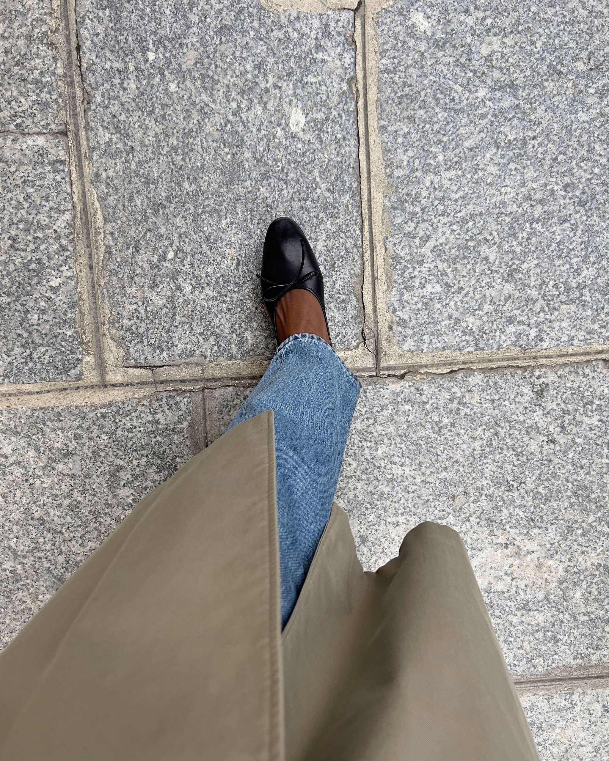 Woman in a trench, jeans, and ballet flats