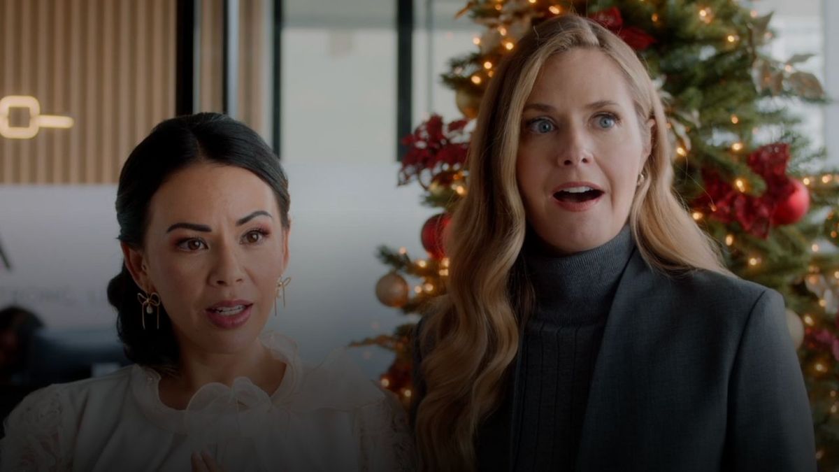 Janell Parrish in a white colared shirt looking confused and Maggie Lawson in a gray coat with a look of shock on her face in Hallmark&#039;s Sugarplummed