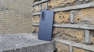 The OnePlus Nord 5 against a brick wall.