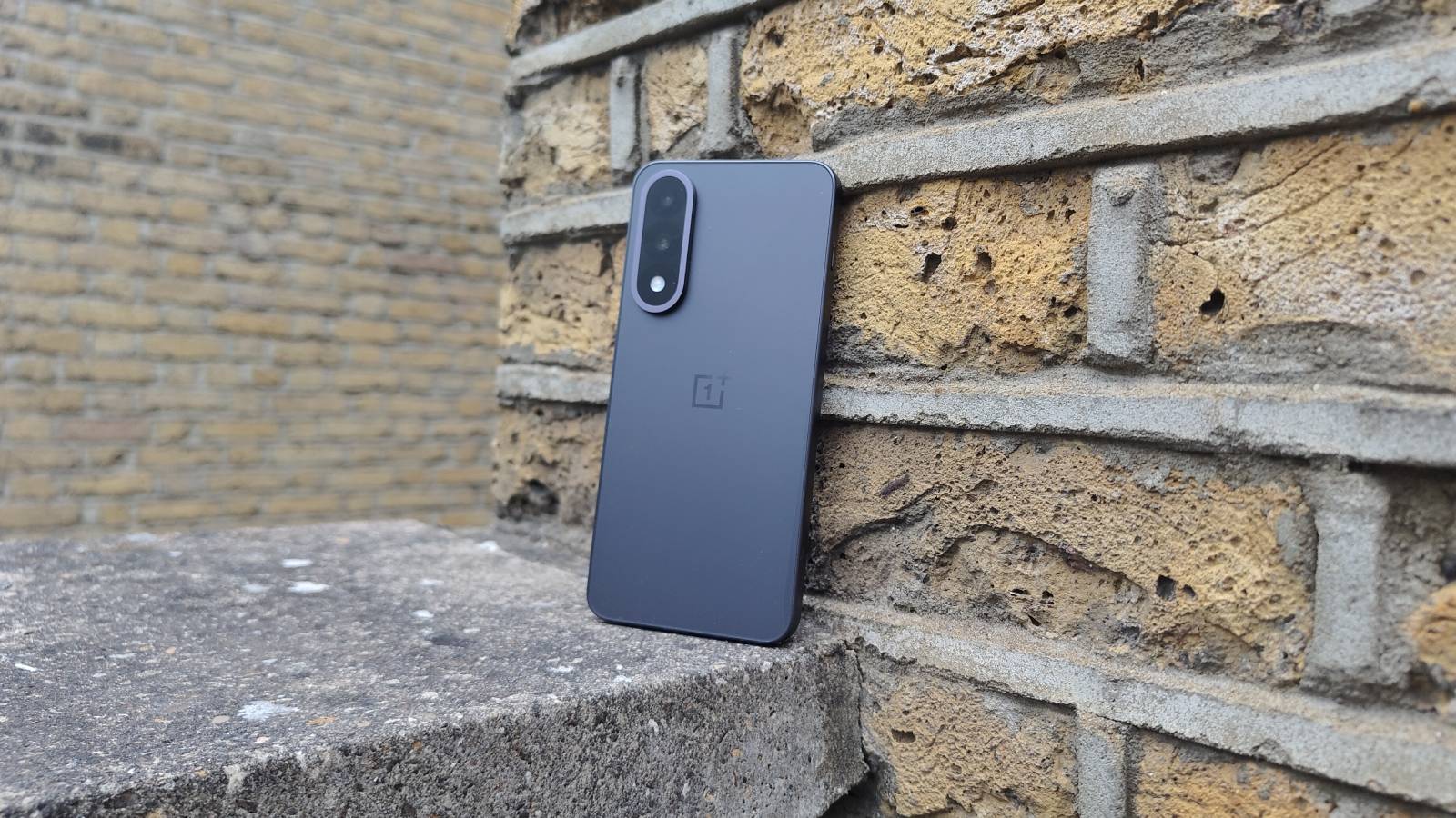 The OnePlus Nord 5 against a brick wall.