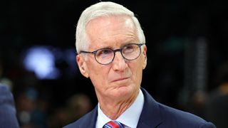 Mike Breen with a suit on standing during an NBA game.