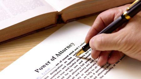 A man fills out power of attorney paperwork.
